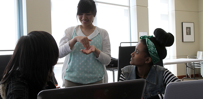 A computing student uses sign language to collaborate with others