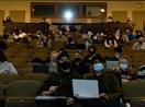 Students in an auditorium with a projector running.