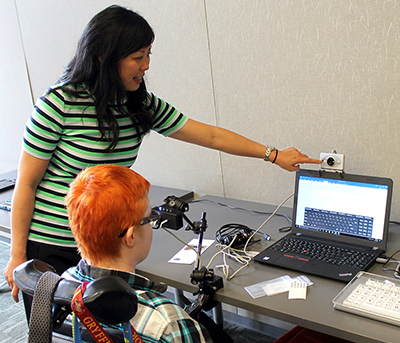A mentor shows a student how to use an eye tracking camera.