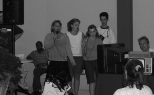 Image of students with disabilities at a podium speaking to an audience.