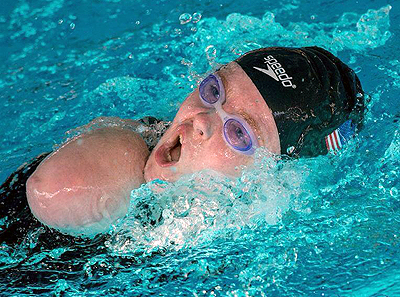 Photo of DO-IT Scholar Kayla turning to take a breath during a swimming competition 